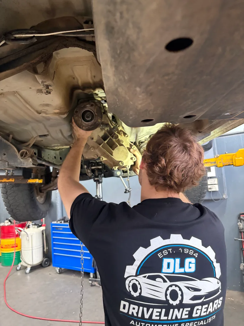 Driveline Gears mechanic refitting a tailshaft under a 4WD on the hoist