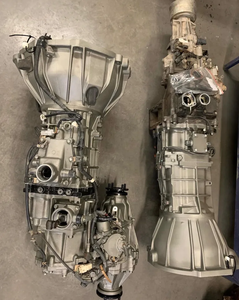 Two rebuilt gearbox and transfer case assemblies side by side in the workshop