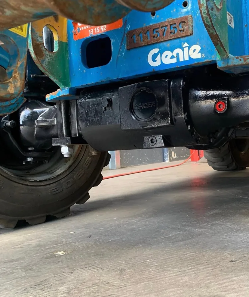 Rebuilt differential and axle fitted under a blue Genie boom lift