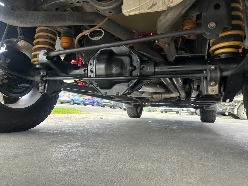 Underside of a lifted 4WD showing the front differential, tailshaft and suspension